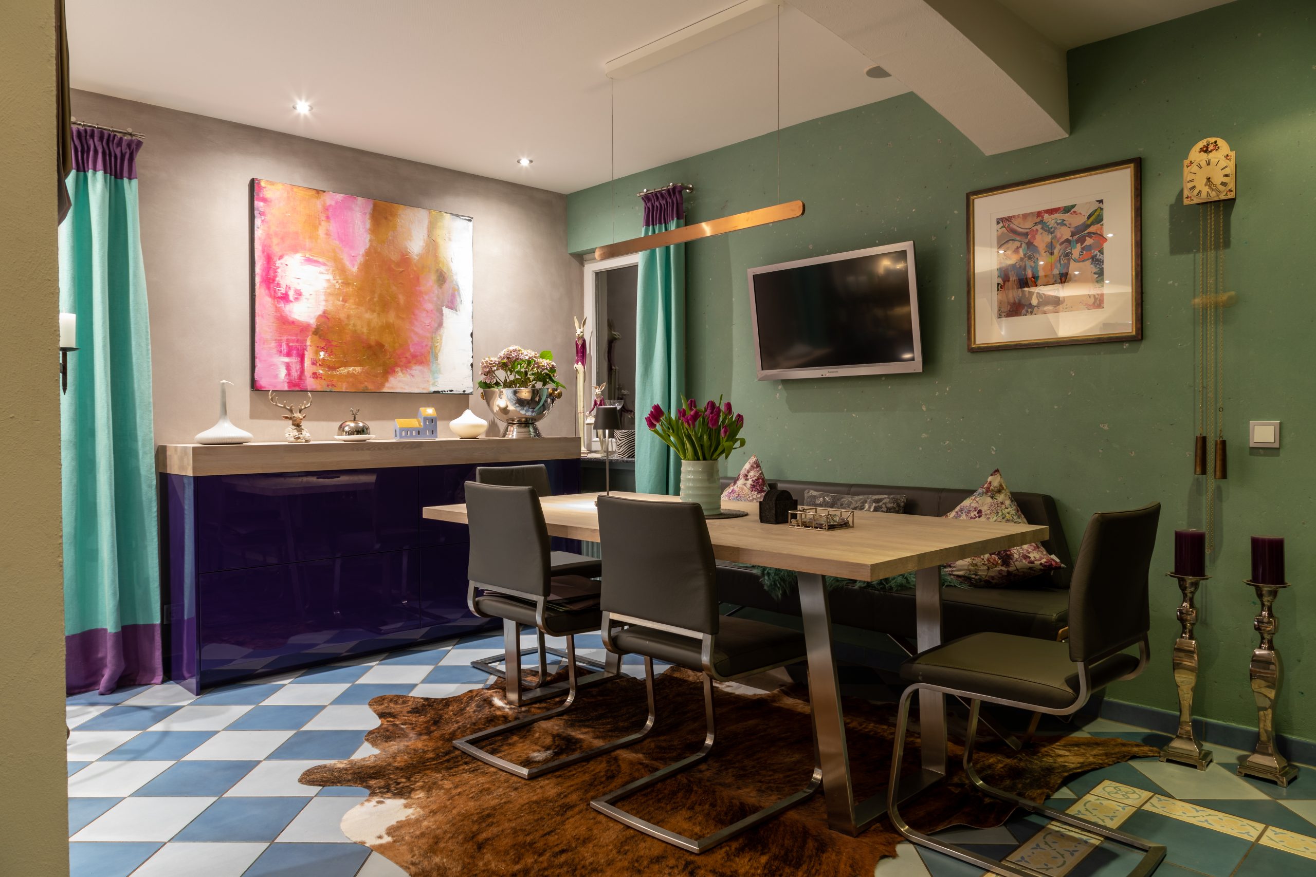 Bunter Essbereich mit Kunst, Fernseher und modernem Materialmix