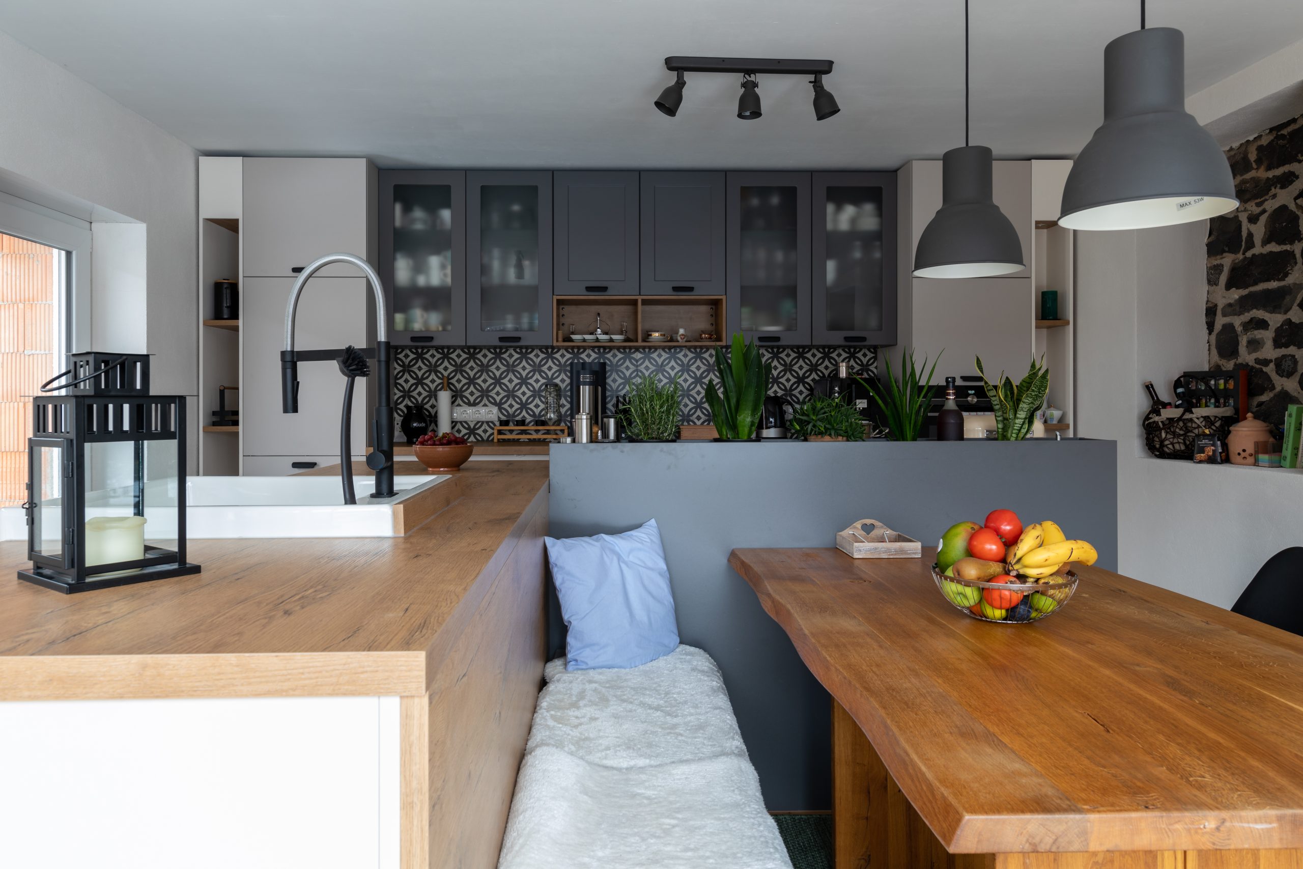 Gemütliche Wohnküche mit Naturholztisch, Sitzbank und vielen Pflanzen