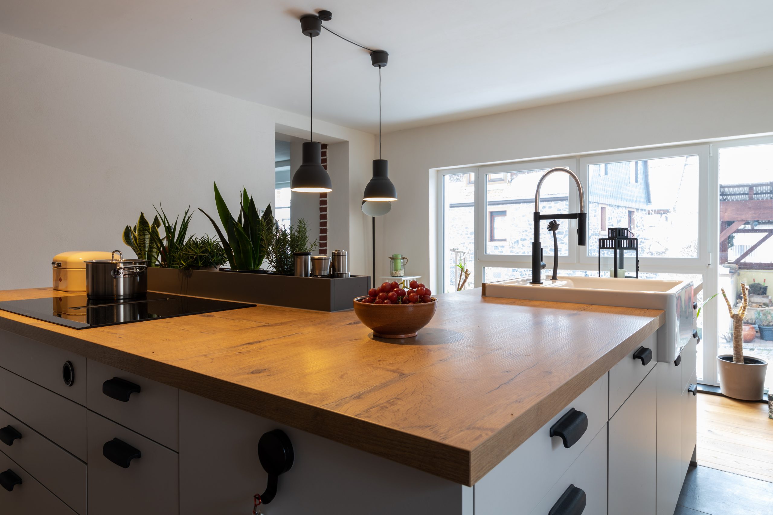 Wohnküche mit Massivholz, Hängelampen und heller Beleuchtung