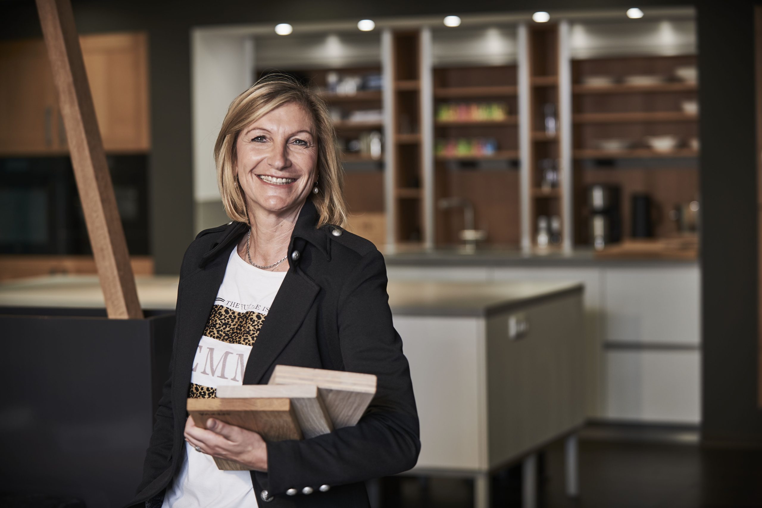 Frau mit Musterplatten in moderner Küchenausstellung